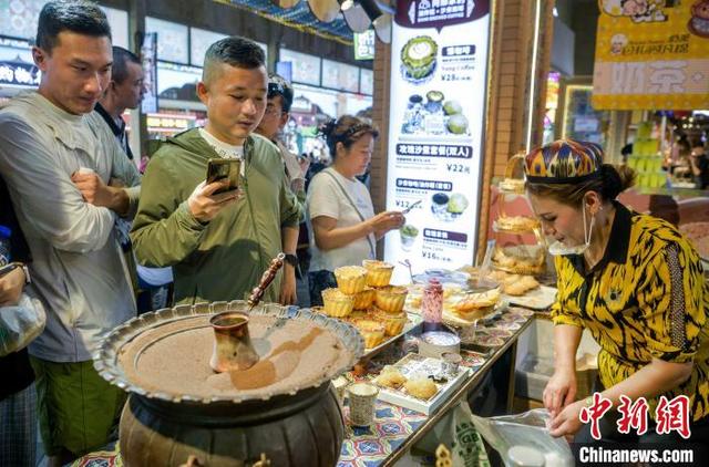 乌鲁木齐：游客大巴扎里看歌舞品美食感受新疆风情