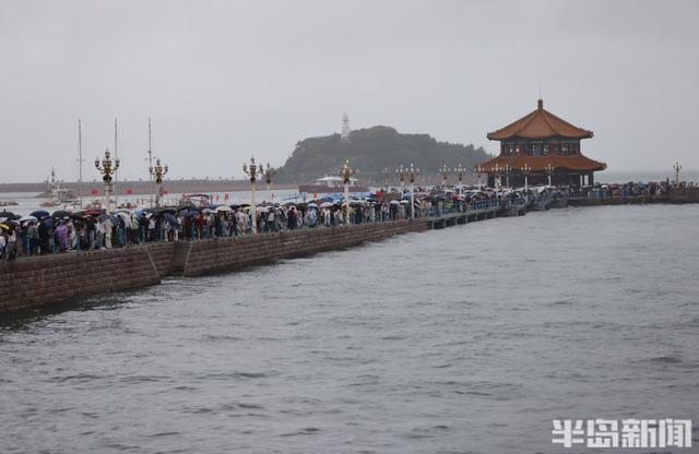 秋雨润栈桥，伞海映人潮
