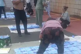 新生报到第一天，学生家长在地上帮孩子缝被子，网友：到了拼妈妈的时候了。图片