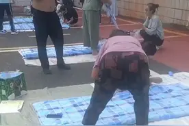 新生报到第一天，学生家长在地上帮孩子缝被子，网友：到了拼妈妈的时候了。图片