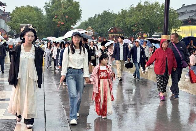 漫步不夜城 雨天游客热情不减