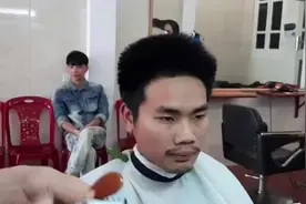 男子头发竖着长，四周都炸毛，理发师拿起工具就全推了