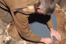 原始技术，野外用兽皮制作衣服。