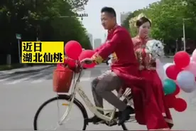 #新郎骑自行车接亲一路收获祝福 近日，湖北仙桃。某路段迎来一对身穿红色传统礼服且骑着自行车结婚的新人。一路上，路人纷纷拍照祝福，二人脸上洋溢着幸福的笑容 #接亲 #婚礼 #爱情 #自行车 视频封面