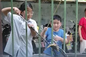 7月18日，江苏南京，小孩哥姐简陋装备钓大鱼，围观老小乐开花，网友：受伤的只有钓鱼佬！