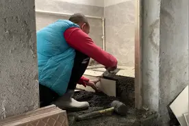 贴厕所瓷砖，先把地砖画好再铺平，然后在抹上水泥油开贴