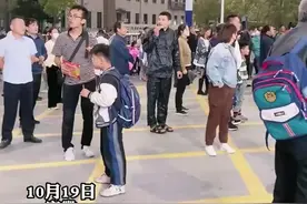 爸爸在校门口买了包辣条，边吃边等孩子放学图片