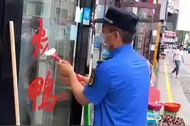 城管铲掉商户玻璃门红字称“创文办要来检查”，商户：也没提前说不能贴图片