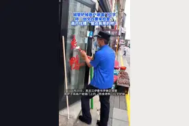 城管铲掉商户玻璃门红字称“创文办要来检查”，商户：也没提前说不能贴图片