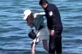 青岛一女孩突遇涨潮被困礁石，民警一边大声安慰一边蹚水营救。网友：安全感在这一刻具象化！图片
